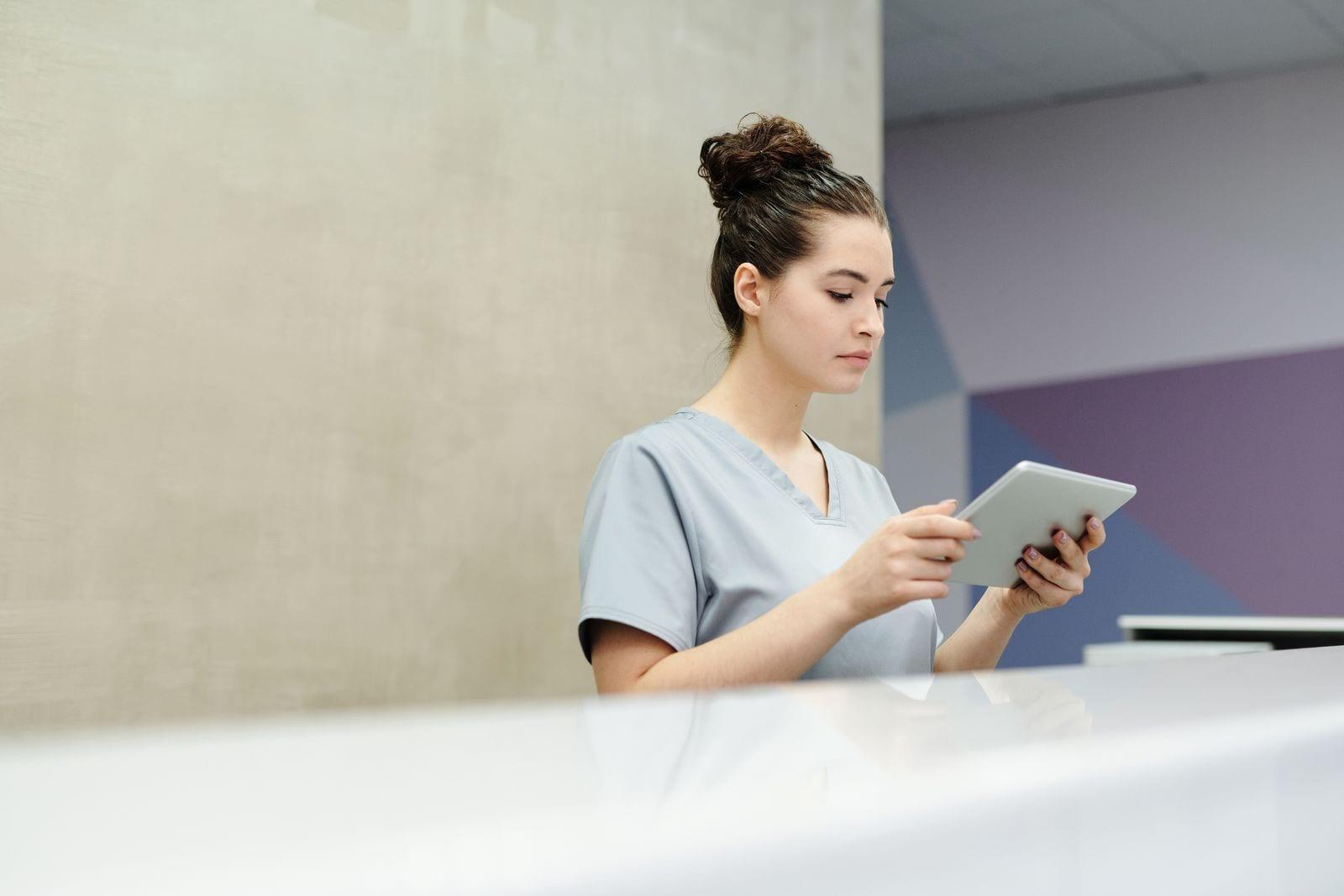 Nurse reading a tablet at a hospital reception